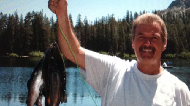 Weisser Mann präsentiert an einem See gefangene Fische. Weisser Mann präsentiert an einem See gefangene Fische.
