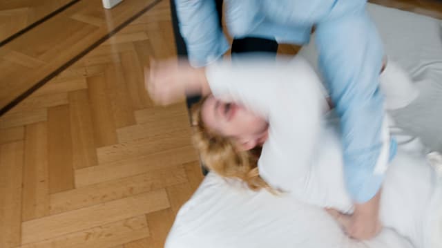 Ein Mann wirft eine Frau auf den Boden Ein Mann wirft eine Frau auf den Boden