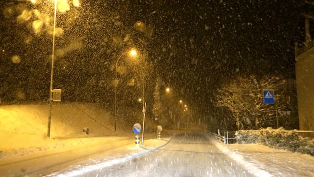 Schneefall in der Nacht, die Strasse ist schneebedeckt. Schneefall in der Nacht, die Strasse ist schneebedeckt.