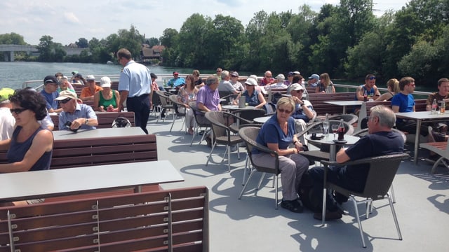 Personen auf dem Deck eines Aareschiffs, an Tischen sitzend Personen auf dem Deck eines Aareschiffs, an Tischen sitzend