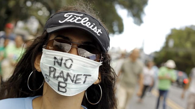 Eine Demonstrantin trägt einen Mundschutz mit der Aufschrift «No Planet B» Eine Demonstrantin trägt einen Mundschutz mit der Aufschrift «No Planet B»