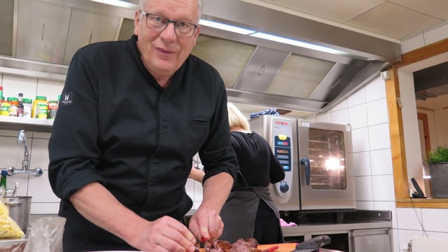 Walter Käser schneidet in der Küche eine Ramser-Wurst. Walter Käser schneidet in der Küche eine Ramser-Wurst.