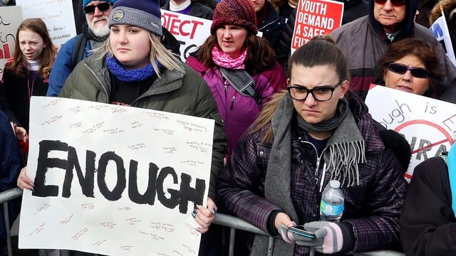 Protestierende Schülerinnen, eine von ihnen hält ein Plakat mit der Aufschrift "Enough" vor sich hin. Protestierende Schülerinnen, eine von ihnen hält ein Plakat mit der Aufschrift "Enough" vor sich hin.