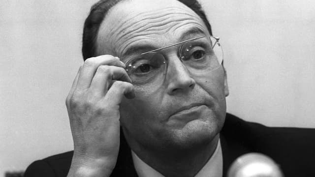 Schwarz-weiss-Aufnahme von Tournier, der eine Brille trägt. Schwarz-weiss-Aufnahme von Tournier, der eine Brille trägt.