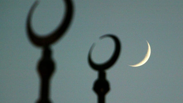 Mondsichel neben der Spitze einer Moschee. Mondsichel neben der Spitze einer Moschee.