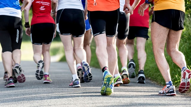 Beine von Joggern und Joggerinnen, die dicht beieinander laufen. Beine von Joggern und Joggerinnen, die dicht beieinander laufen.