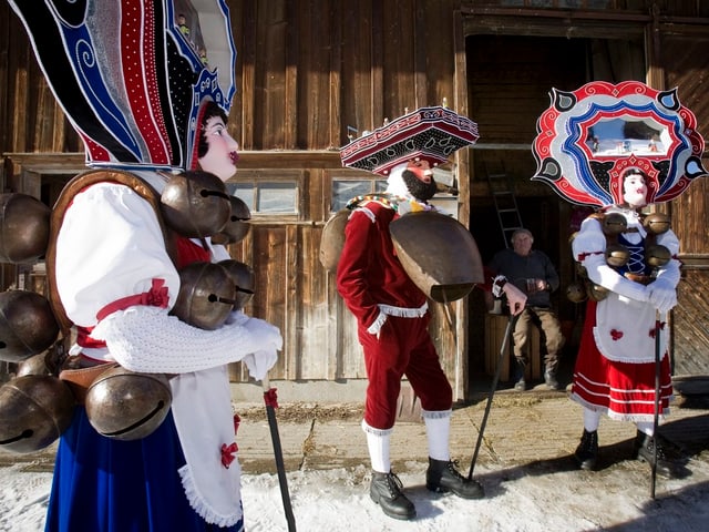 Eine Gruppe von schönen Silvesterchläusen steht vor einem Hof und jodelt. Eine Gruppe von schönen Silvesterchläusen steht vor einem Hof und jodelt.