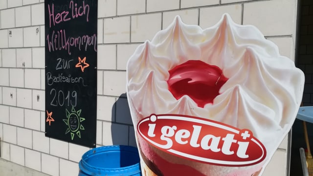 Schild: "Herzlich Willkommen" neben Glace-Steller. Schild: "Herzlich Willkommen" neben Glace-Steller.