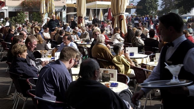 Service-Fachmann, Restaurant-Gäste im freien an Tischen sitzend. Service-Fachmann, Restaurant-Gäste im freien an Tischen sitzend.