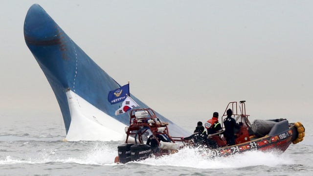 Die Spitze der Fähre ragt aus den Fluten, ein Boot umfährt das Wrack. Die Spitze der Fähre ragt aus den Fluten, ein Boot umfährt das Wrack.