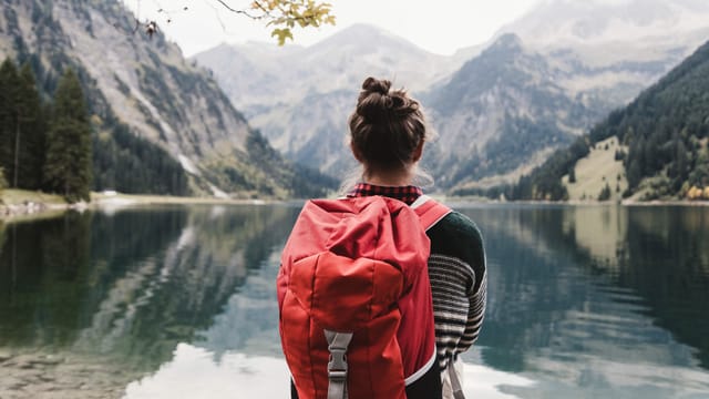 Eine Frau mit Rucksack vor einem Alpsee. Eine Frau mit Rucksack vor einem Alpsee.