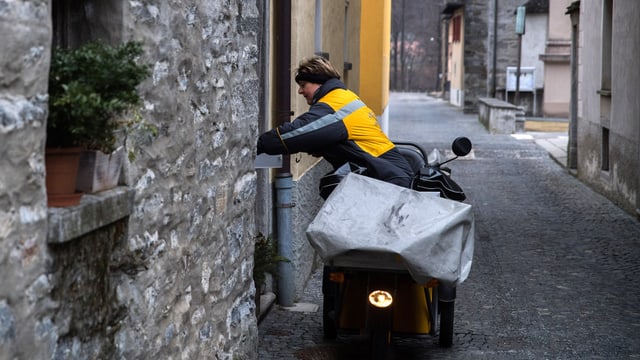 Pöstlerin in einem Dorf mit ihrem Moped unterwegs. Pöstlerin in einem Dorf mit ihrem Moped unterwegs.