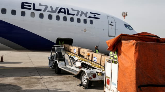 Ein Arbeiter verlädt am Flughafen in Tel Aviv Pakete mit Hilfsgütern für die Ukraine.