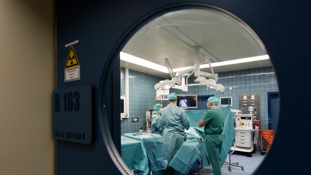 Blick durch die Tür eines besetzten Operationssaals. Blick durch die Tür eines besetzten Operationssaals.