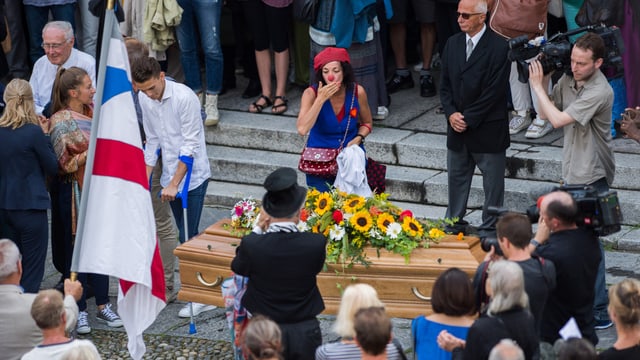 Menschenmenge um den Sarg von Dimitri, eine Clownin wirft eine Kusshand zu Menschenmenge um den Sarg von Dimitri, eine Clownin wirft eine Kusshand zu