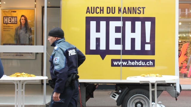 Ein Poliziste vor einem Plakat Ein Poliziste vor einem Plakat