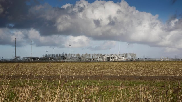 Ein grosses Feld mit einer Gasförderanlage am Horizont. Ein grosses Feld mit einer Gasförderanlage am Horizont.