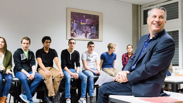Reto Lipp sitzt auf Schulbank und blickt über seine Schulter. Reto Lipp sitzt auf Schulbank und blickt über seine Schulter.