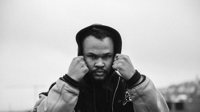 schwarzweiss bild des kapuzentragenden böse blickenden rappers schwarzweiss bild des kapuzentragenden böse blickenden rappers