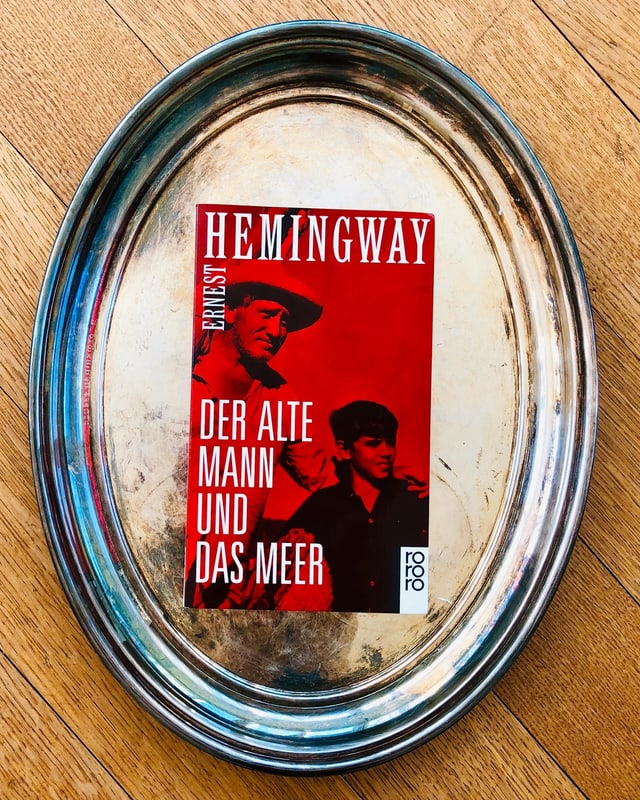 «Der alte Mann und das Meer» von Ernest Hemingway liegt auf einem Silbertablett «Der alte Mann und das Meer» von Ernest Hemingway liegt auf einem Silbertablett