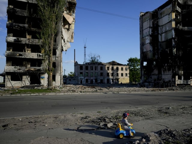 Ein Junge spielt in Borodyanka bei Kiew vor Häusern, die durch Granatenbeschuss zerstört wurden. (24. Mai 2022)