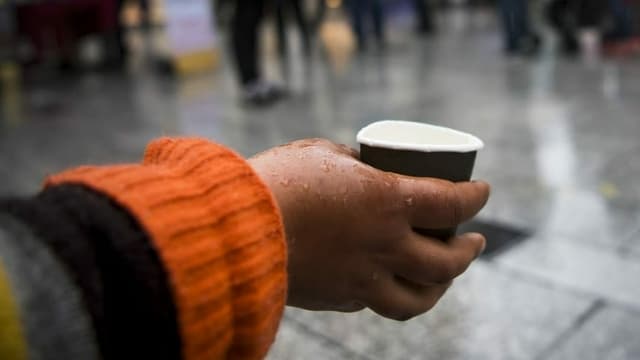 Eine Frau hält einen Becher Eine Frau hält einen Becher