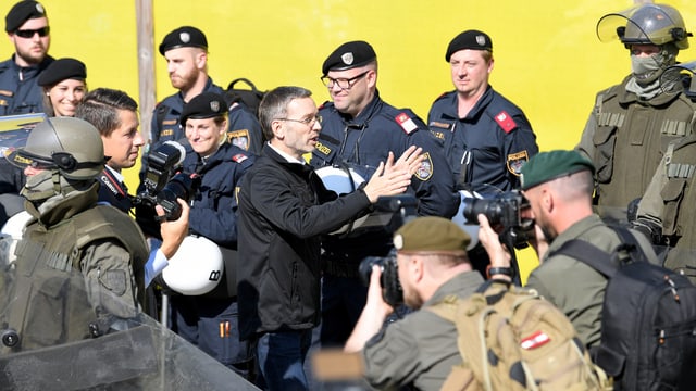 Mann in Anztug umringt von Soldaten und Polizisten. Mann in Anztug umringt von Soldaten und Polizisten.