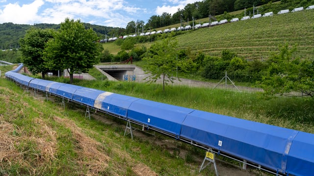 Förderband für Aushubmaterial, dahinter Autobahn und Bahngeleise mit Güterzug Förderband für Aushubmaterial, dahinter Autobahn und Bahngeleise mit Güterzug