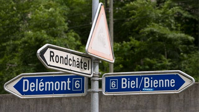 Ein Wegweiser zeigt nach Delémont und nach Biel. Ein Wegweiser zeigt nach Delémont und nach Biel.