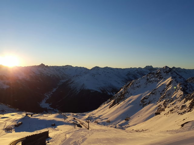 Winterlandschaft, Skipiste, blauer Himmel, Sonnenaufgang.