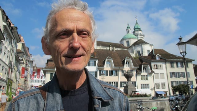 Im Vordergrund Ueli Steiner mit einer Jeansjacke, im Hintergrund die Solothurner Altstadt mit der St. Ursenkathedrale. Im Vordergrund Ueli Steiner mit einer Jeansjacke, im Hintergrund die Solothurner Altstadt mit der St. Ursenkathedrale.