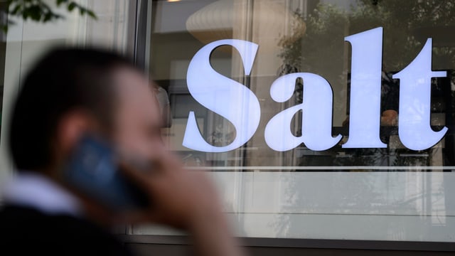 Ein Mann telefoniert vor einem Salt-Laden Ein Mann telefoniert vor einem Salt-Laden