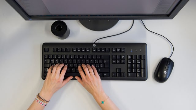 Frauenhände an einer Computertastatur Frauenhände an einer Computertastatur