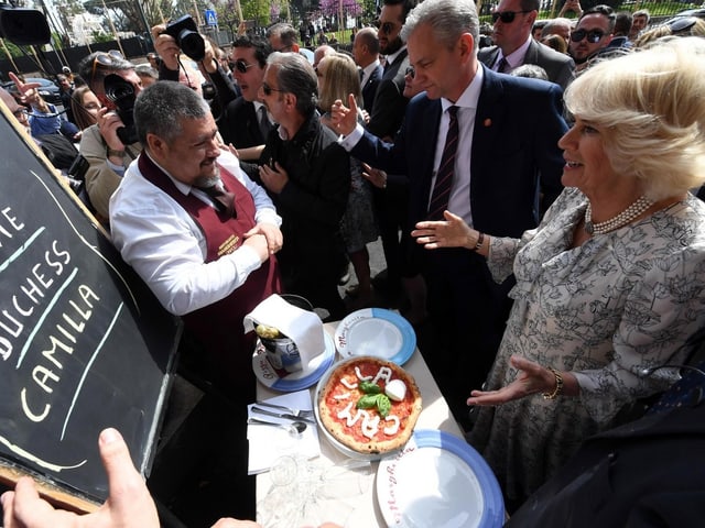 Camilla steht vor einem Tisch, auf dem eine Pizza liegt. Aus Mozzarella ist darauf ihr name geformt. Camilla steht vor einem Tisch, auf dem eine Pizza liegt. Aus Mozzarella ist darauf ihr name geformt.
