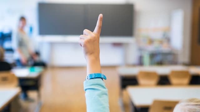 Schulzimmer. Jemand streckt die Hand auf. Schulzimmer. Jemand streckt die Hand auf.