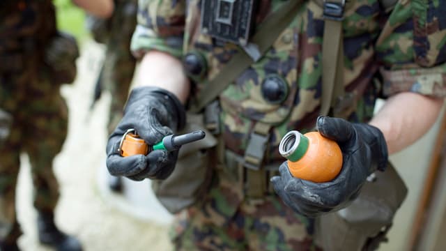Rekrut mit einer Übungshandgranate, die lediglich einen Knall auslöst. Rekrut mit einer Übungshandgranate, die lediglich einen Knall auslöst.