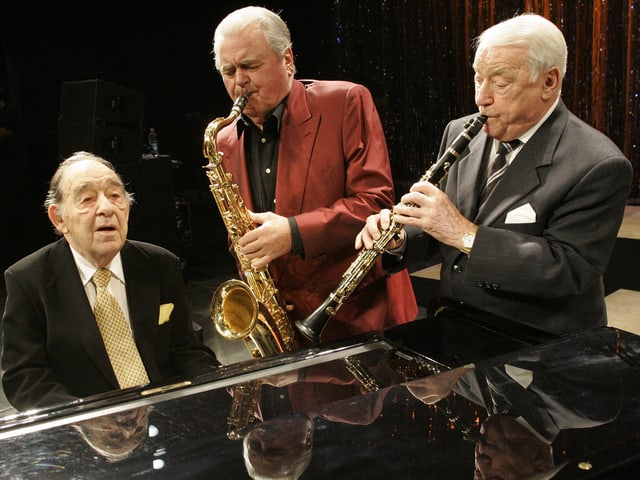 Die drei Musiker spielen gemeinsam während eines Konzerts. Die drei Musiker spielen gemeinsam während eines Konzerts.