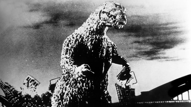 Ein Still aus dem Godzilla-Film: Godzilla zerstört eine Brücke. Ein Still aus dem Godzilla-Film: Godzilla zerstört eine Brücke.