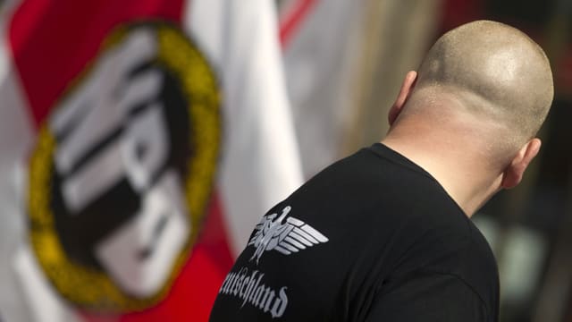 Neonazi vor NPD-Flagge Neonazi vor NPD-Flagge