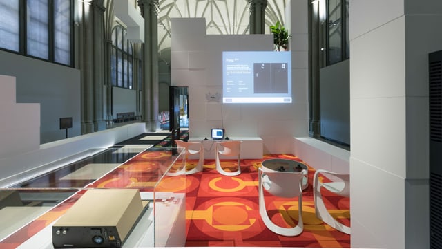Blick in einen Museumsraum mit orangefarbenem Teppich. Blick in einen Museumsraum mit orangefarbenem Teppich.