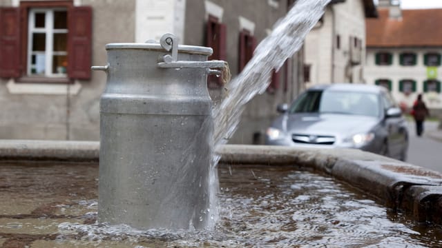 Eine Milchkanne steht in einem Brunnen zur Kühlung. Eine Milchkanne steht in einem Brunnen zur Kühlung.