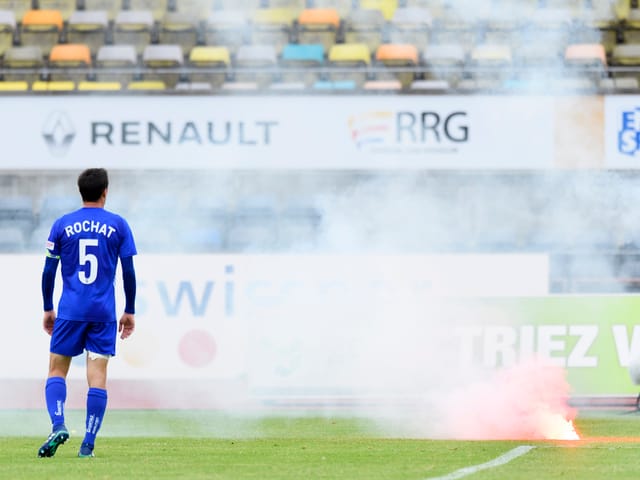 Ein Lausanne-Spieler neben einer brennenden Petarde. Ein Lausanne-Spieler neben einer brennenden Petarde.