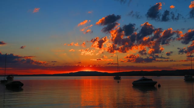Sonnenaufgang mit Quellwolken über dem Murtensee Sonnenaufgang mit Quellwolken über dem Murtensee