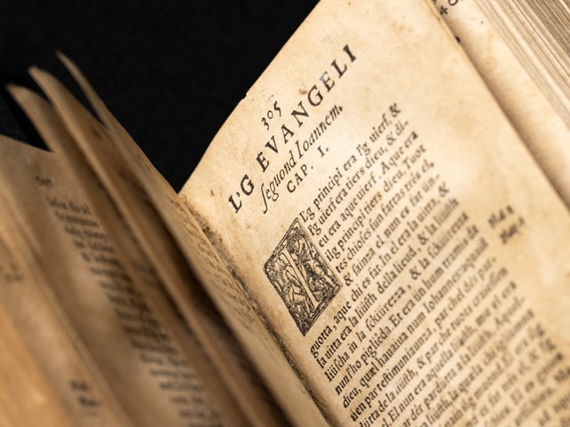 Eine sehr vergilbte Seite der Bibel mit rätoromanischem Text Eine sehr vergilbte Seite der Bibel mit rätoromanischem Text