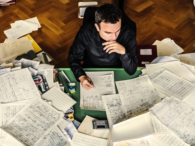 Jörg Widmann mit Blättern. Darauf sind Kompositionen. Jörg Widmann mit Blättern. Darauf sind Kompositionen.