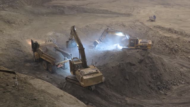 Zwei Bagger beladen einen Lastwagen in der Sondermülldeponie. Zwei Bagger beladen einen Lastwagen in der Sondermülldeponie.