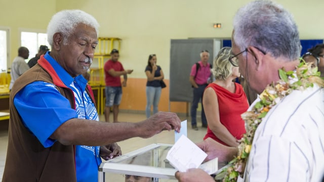 Zwei Männer legen ihre Stimmzettel in die Wahlurnen. Zwei Männer legen ihre Stimmzettel in die Wahlurnen.