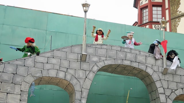 Kostümierte Leute führen auf einer Brücke ein Fasnachtstheater auf. Kostümierte Leute führen auf einer Brücke ein Fasnachtstheater auf.
