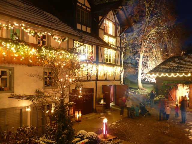 Ein mit Lichterketten und weiteren Weihnachtsdekorationen geschmückter Hof. Ein mit Lichterketten und weiteren Weihnachtsdekorationen geschmückter Hof.