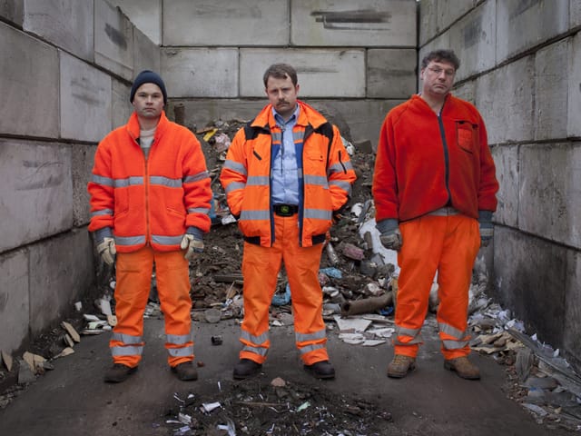 Drei Männer in Reiningungsanzügen. Drei Männer in Reiningungsanzügen.